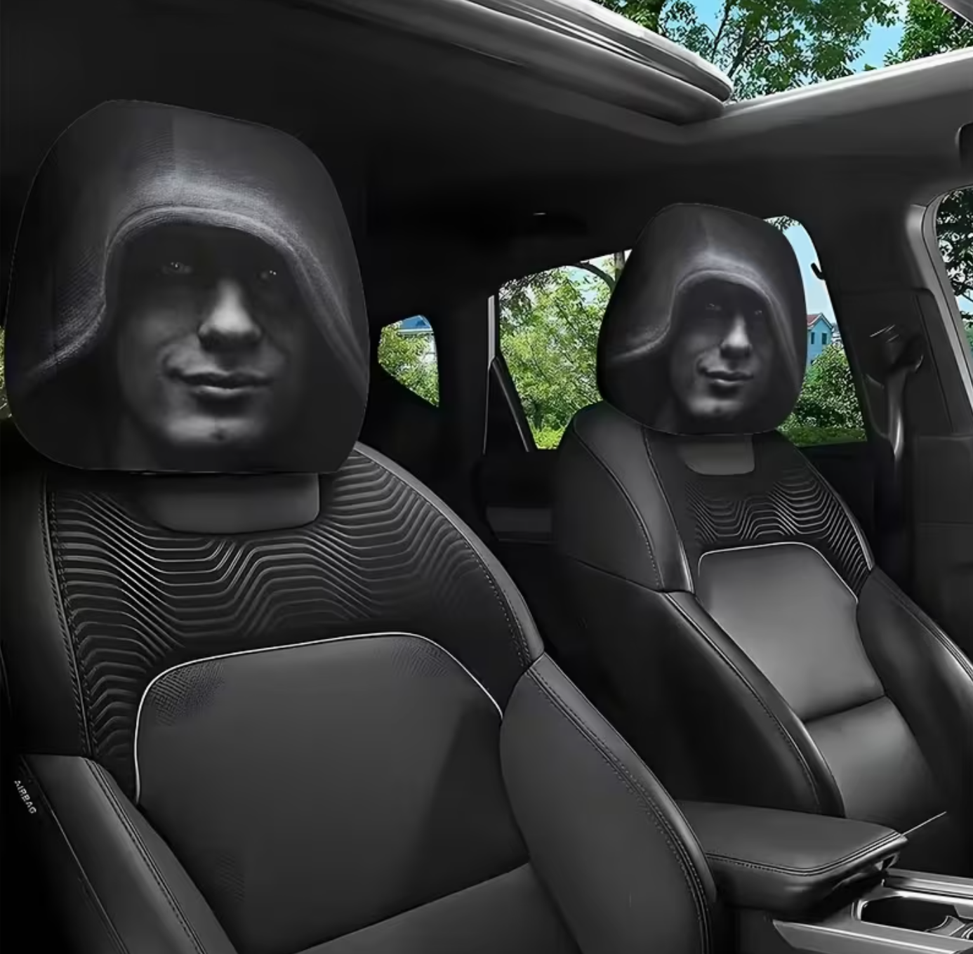 Custom black car seat covers installed on the front seats of a vehicle, featuring a printed design of a hooded figure with a face.